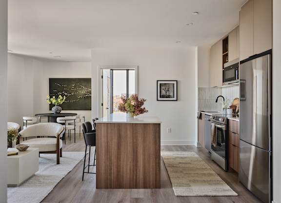 A modern kitchen with a wooden island and stainless steel appliances.