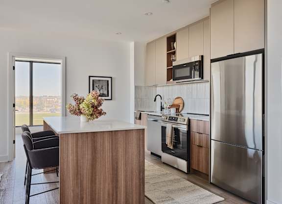 A modern kitchen with a wooden island and stainless steel appliances.