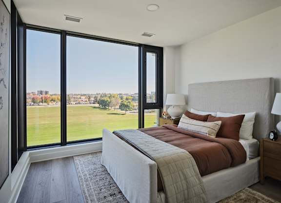 A bedroom with a large bed and a view of the outside.