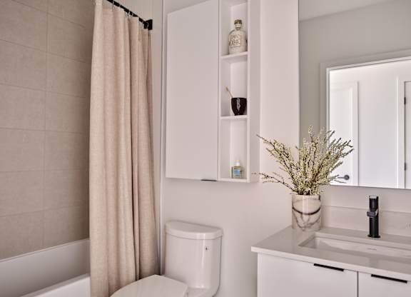 A white toilet sits next to a sink in a modern bathroom.