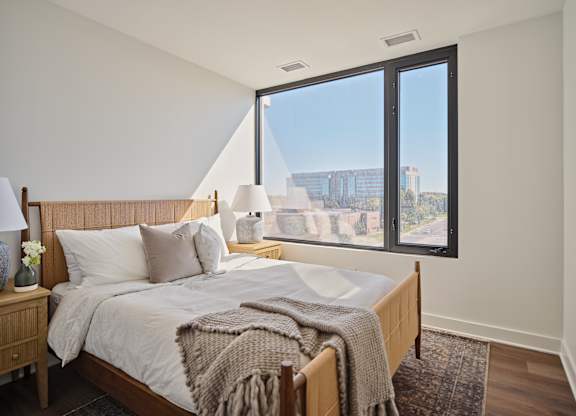 A bedroom with a large bed and a view of the city.