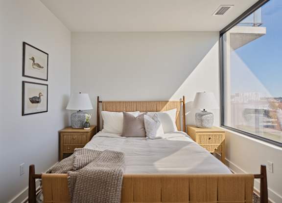 A bedroom with a large bed and a view of the city.