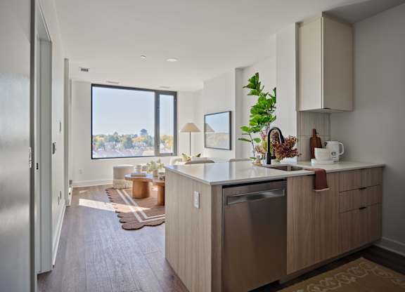 A modern kitchen with a large window overlooking the outdoors.