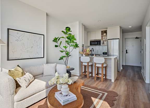 A living room with a couch, a coffee table, and a painting on the wall.