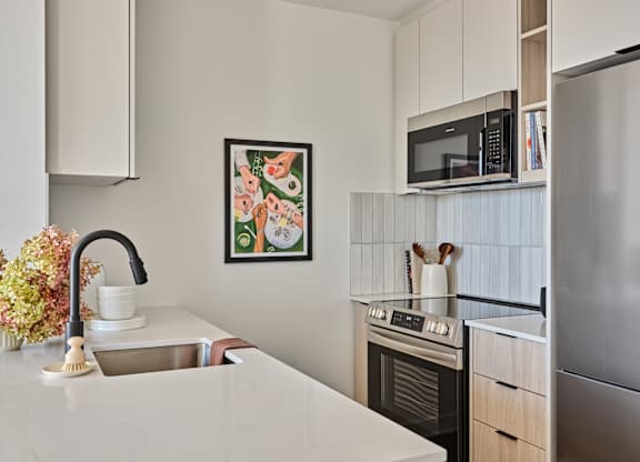A kitchen with a sink, stove, and refrigerator.