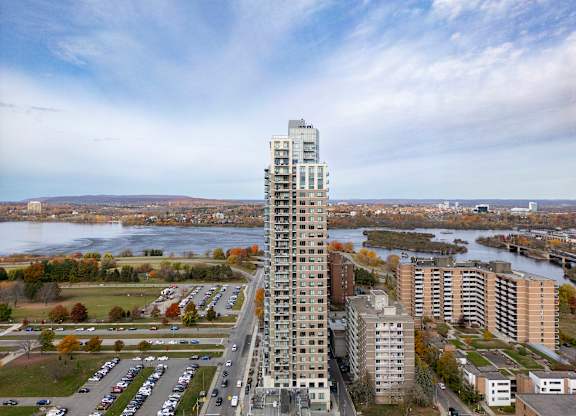 an aerial view of a tall skyscraper next to a river