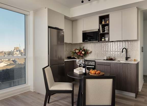 A modern kitchen with a table set for two.