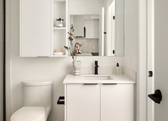 A white bathroom with a toilet, sink, and medicine cabinet.