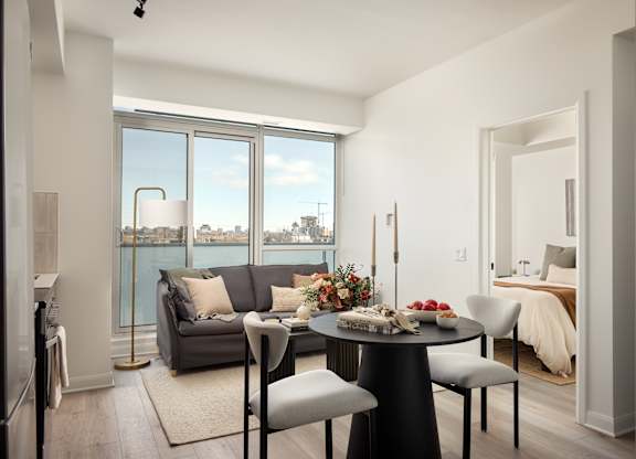 A modern dining room with a table set for four and a view of the city.