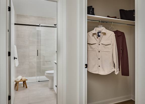 A white bathroom with a walk in shower and a white toilet.