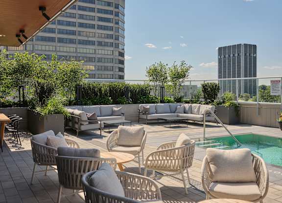 A rooftop with a pool and chairs.