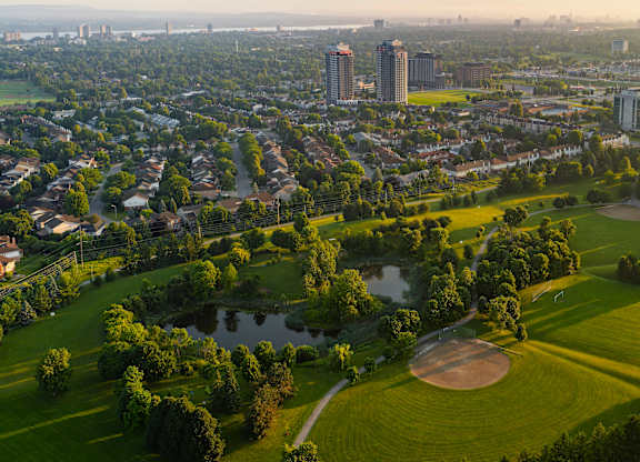A golf course is surrounded by a city.