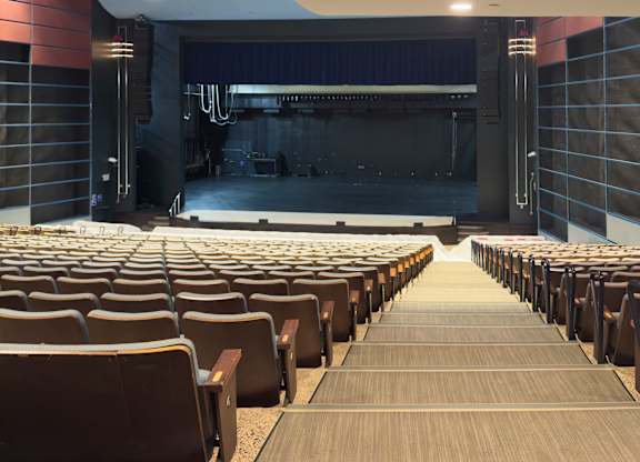 A large auditorium with rows of seats facing a stage.