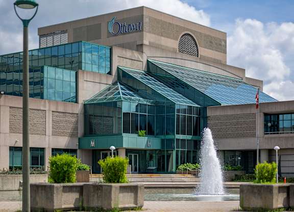 A modern building with a fountain in front.