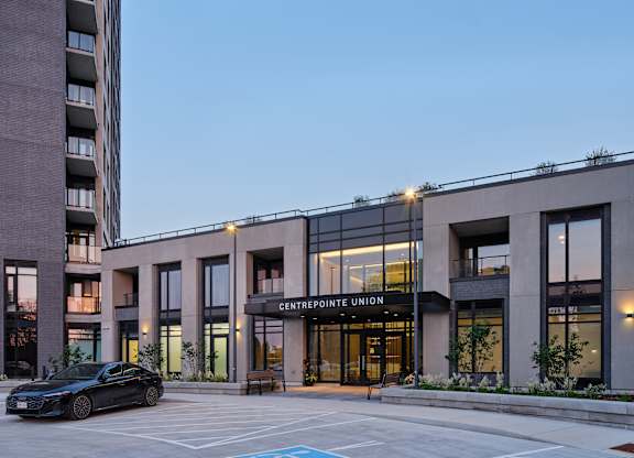 A black car is parked in front of the Centrepointe Union building.