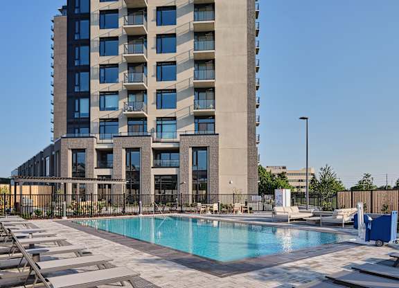 A large building with a pool in front of it.