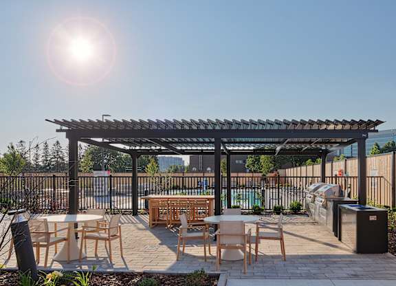 A sunny day at an outdoor patio with tables and chairs.