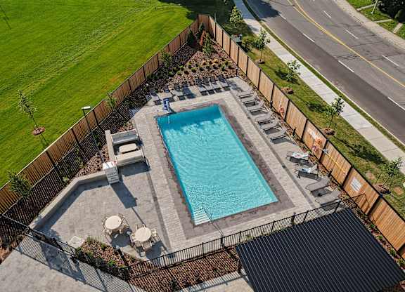 A small rectangular pool surrounded by a fence and a black roof.
