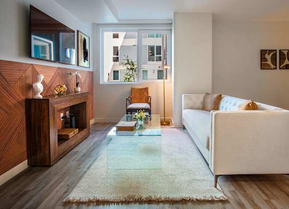 A living room with a white couch and a wooden cabinet.