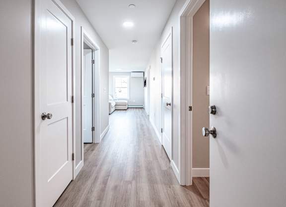 Bright hallway with wood style flooring at Windham Village Apartments, Windham, 04062