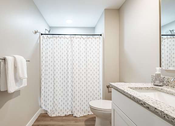 Spacious bathroom with patterned shower curtain at Windham Village Apartments, Windham, 04062