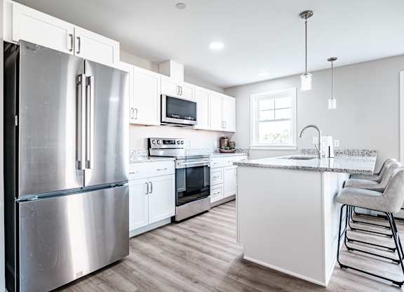 Modern kitchen with white cabinetry and granite countertops at Windham Village Apartments, Windham, Maine
