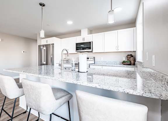 Spacious kitchen island with granite countertops and seating at Windham Village Apartments, Maine