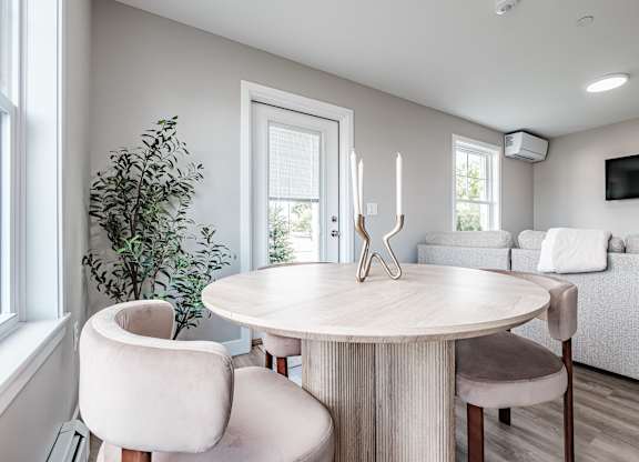 Dining area with round table and upholstered chairs at Windham Village Apartments, Windham, ME