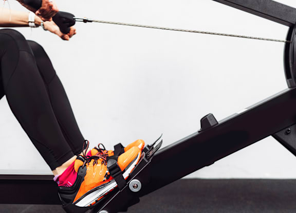 A person is exercising on a rowing machine.