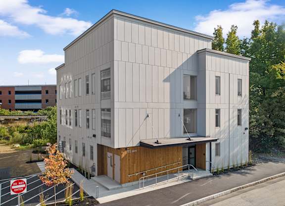 the exterior of a white building with a wood facade