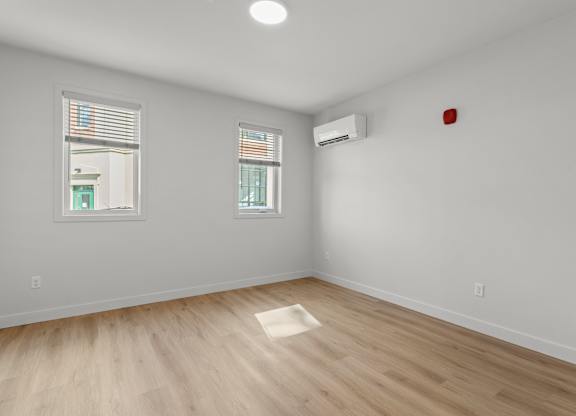 an empty living room with white walls and wood floors