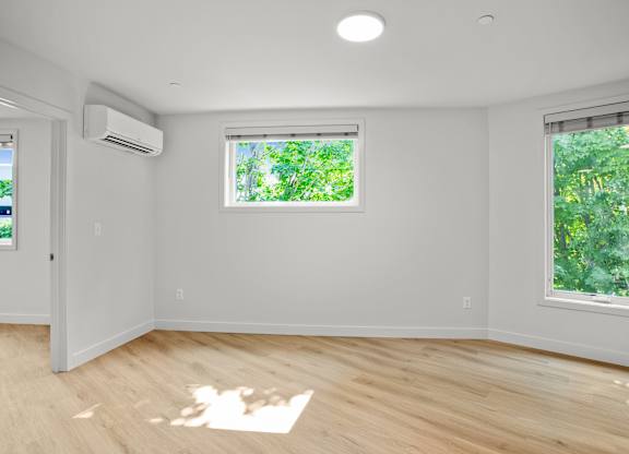 an empty room with white walls and a window