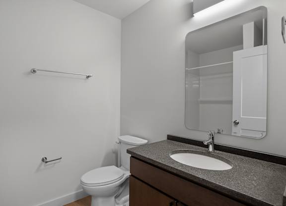 an empty bathroom with a toilet sink and mirror