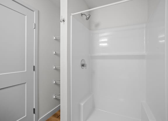 a white bathroom with a shower and a door
