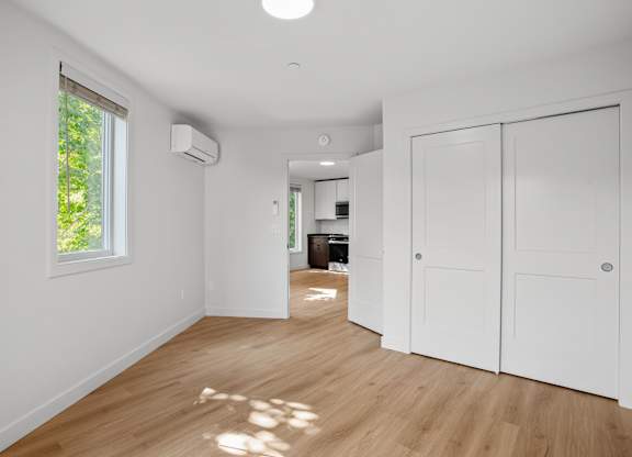 a renovated living room with white walls and wood floors