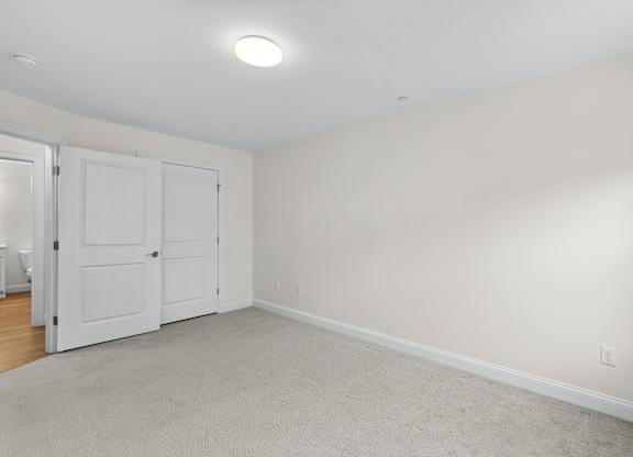 Spacious bedroom with carpeted flooring and closet at Autumn Woods Apartments, Maine
