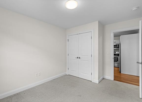 Empty bedroom with carpet and double door closet at Autumn Woods Apartments, Westbrook