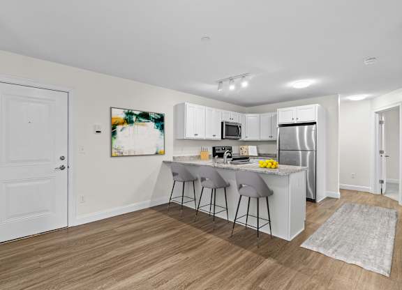 Modern kitchen with white cabinets and breakfast bar at Autumn Woods Apartments, Maine, 04092