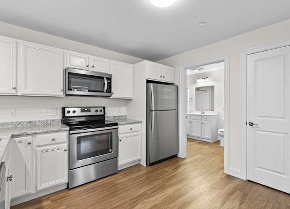 Kitchen with stainless steel appliances and white cabinetry at Autumn Woods Apartments, Westbrook