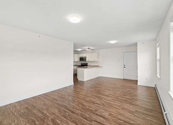 A room with wooden flooring and white walls.