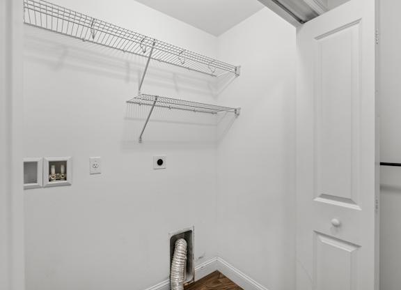 A white wall with a vent and a door.