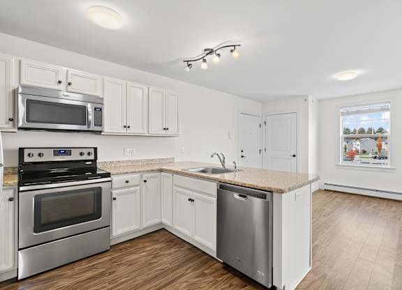 A kitchen with white cabinets and stainless steel appliances.