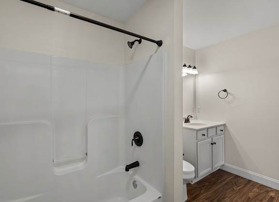 A white bathroom with a walk-in shower and a white sink.