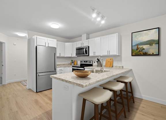 A kitchen with white cabinets and a granite countertop.