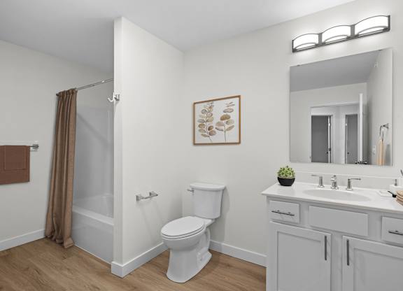 A bathroom with a toilet, sink, and mirror.