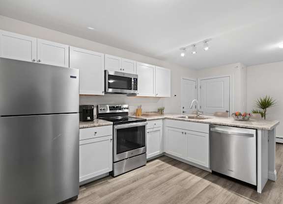 a kitchen with stainless steel appliances and white cabinets