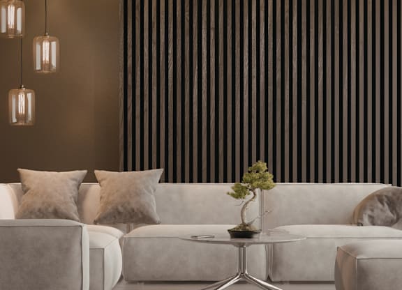 A living room with a white couch, a small table with a plant on it, and a striped wallpaper.