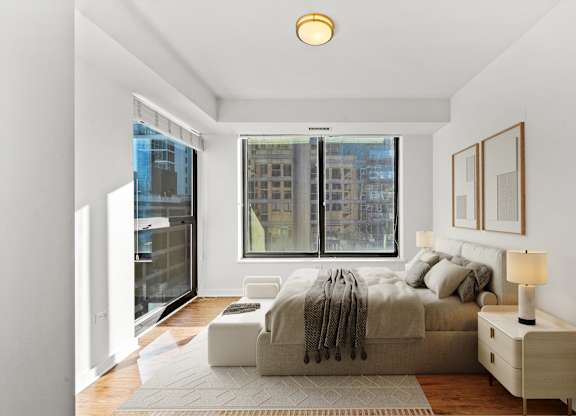 A bedroom with a large bed and a window overlooking a cityscape at Chateau on Wells, Illinois