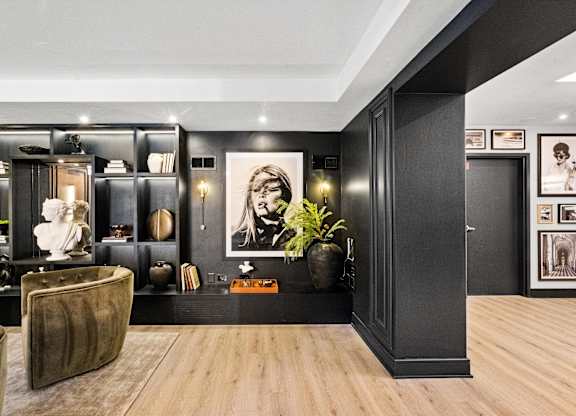 A modern living room with a brown leather chair and a wooden floor at Chateau on Wells, Chicago, IL