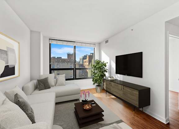 A modern living room with a large window and a flat screen TV. at Chateau on Wells, Chicago, Illinois